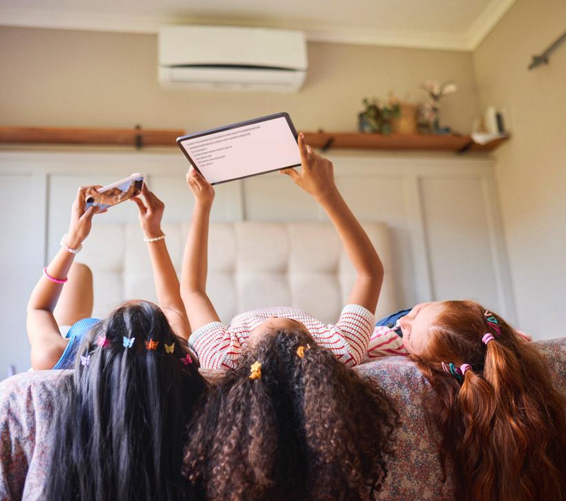 3 girls looking at phone and ipad